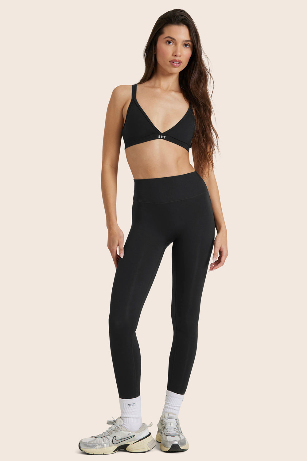 MODEL WEARS AIRLUXE™ BREATHE MID-RISE LEGGINGS IN ONYX