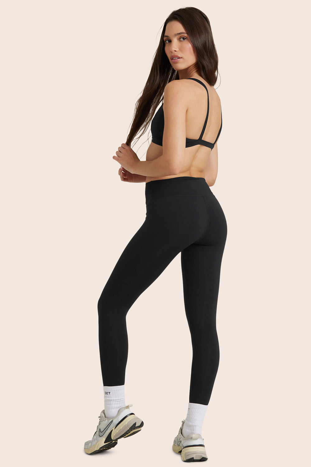 MODEL WEARS AIRLUXE™ BREATHE MID-RISE LEGGINGS IN ONYX