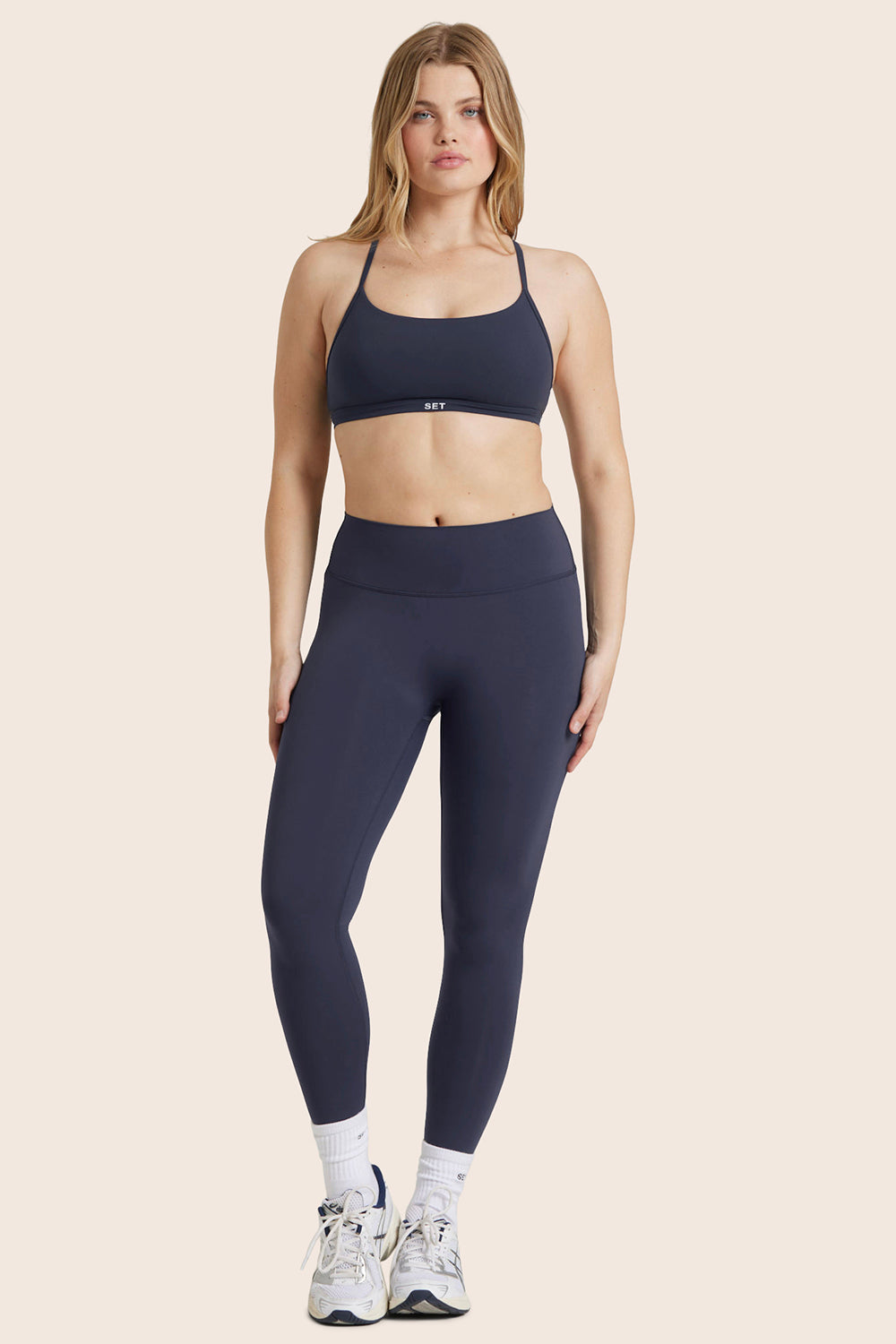 MODEL WEARS BREATHE MID-RISE LEGGINGS IN SPADES 