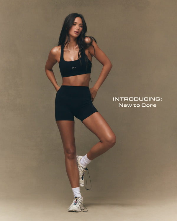 Woman in black athletic wear posing against a beige background with text 'Introducing: New to Core'.