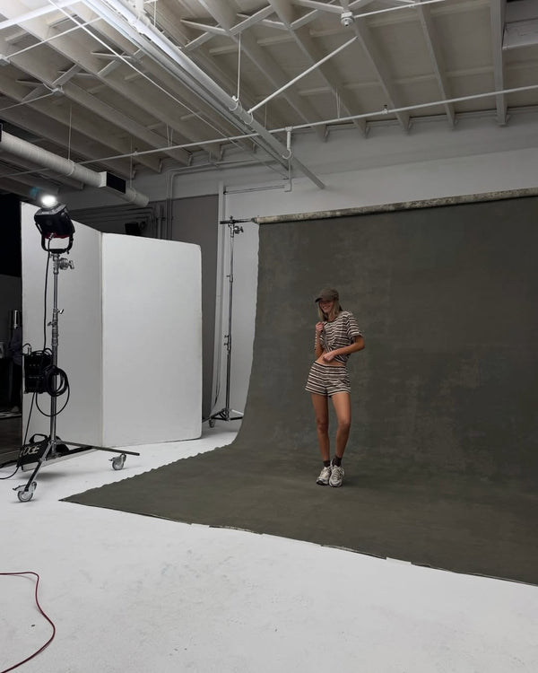 Woman standing with brown striped shirt and matching shorts.