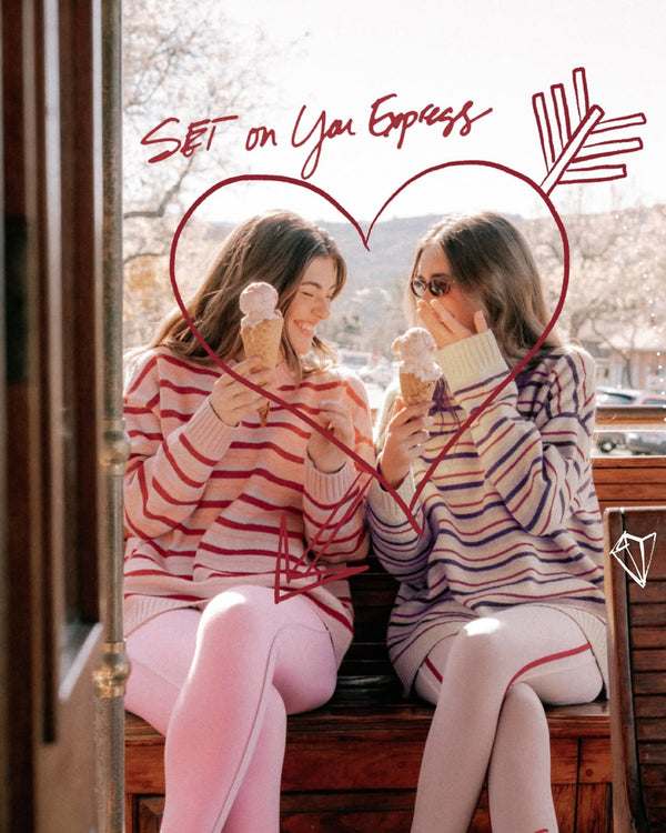 Two girls eating ice cream on a trolley while wearing striped sweaters and leggings