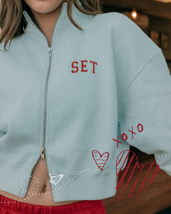 Light blue jacket with red text and designs, worn by a person.