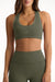 Person wearing an olive green sports bra and leggings set with 'SET' branding.