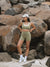 Woman in athletic wear standing on rocky terrain