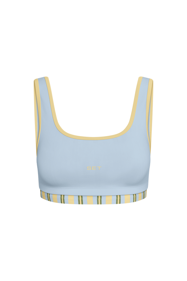 Light blue sports bra with yellow accents on a white background
