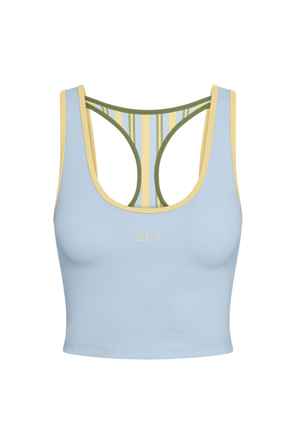 Light blue sports bra with green and yellow straps on a white background