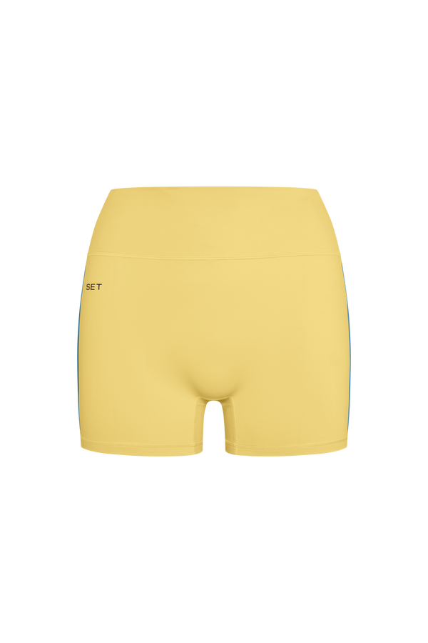 Yellow athletic shorts with a brand logo on a white background