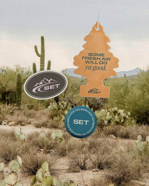 Air freshener with 'SET' branding against a desert landscape background