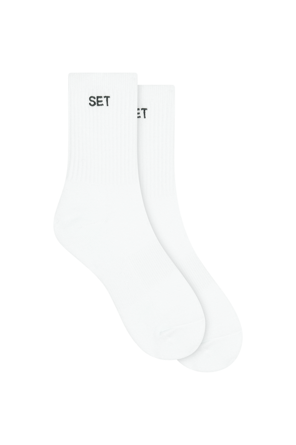 White socks with green 'SET' branding on a white background