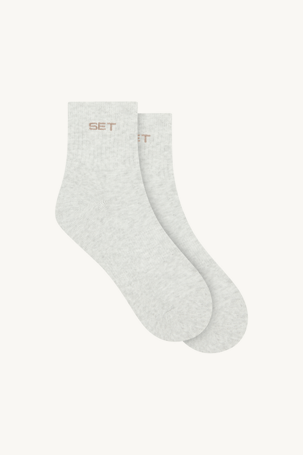 Two pairs of light gray socks with 'SET' branding on a white background
