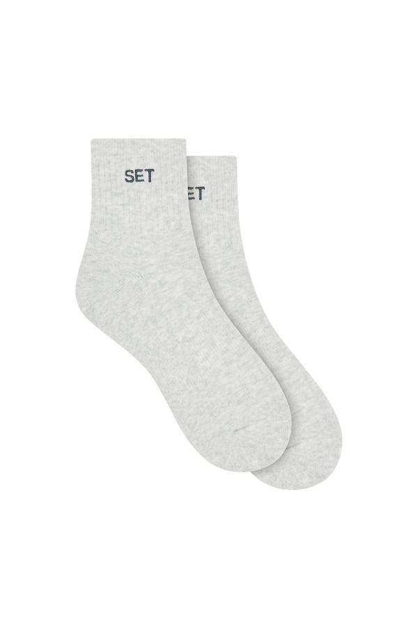 Two gray socks with green 'SET' branding on a white background