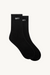 Pair of black socks with 'SET' logo on a beige background 