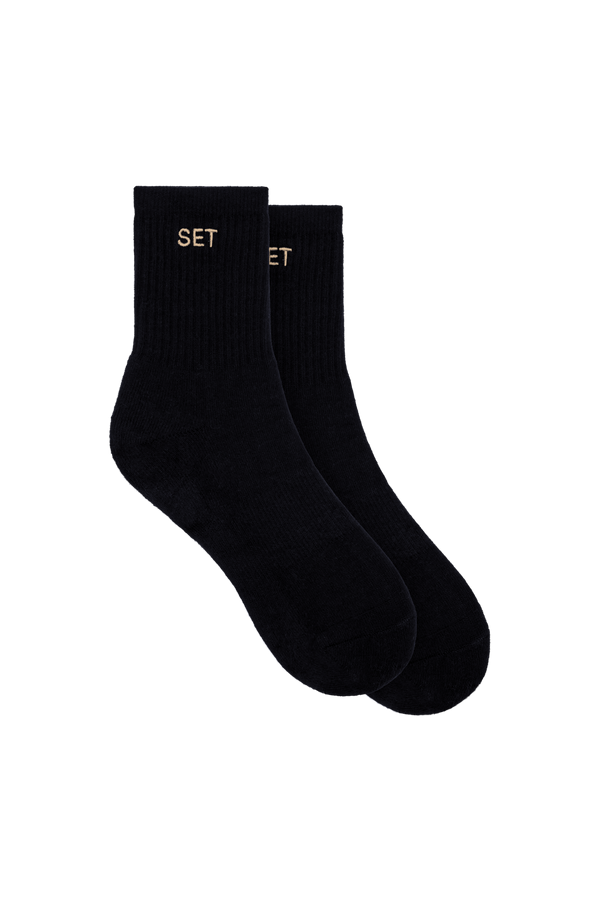 Black socks with tan 'SET' logo on white background
