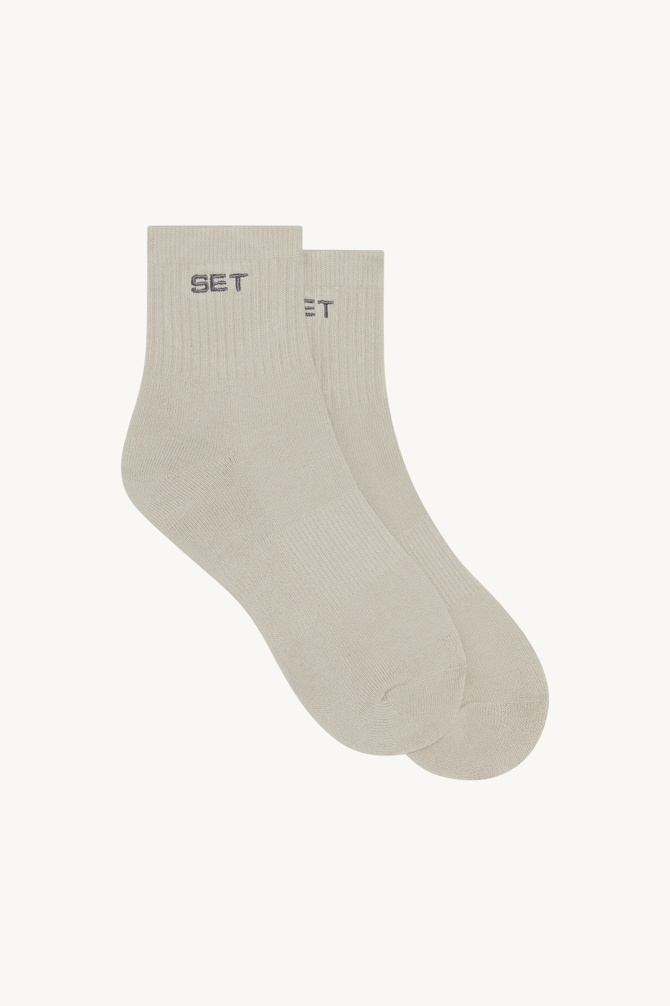 Light gray socks with 'SET' brand logo on a beige background 