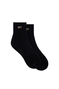 Black ankle socks with tan embroidered 'SET' on cuff (pair, partial 'ET' visible on second sock)