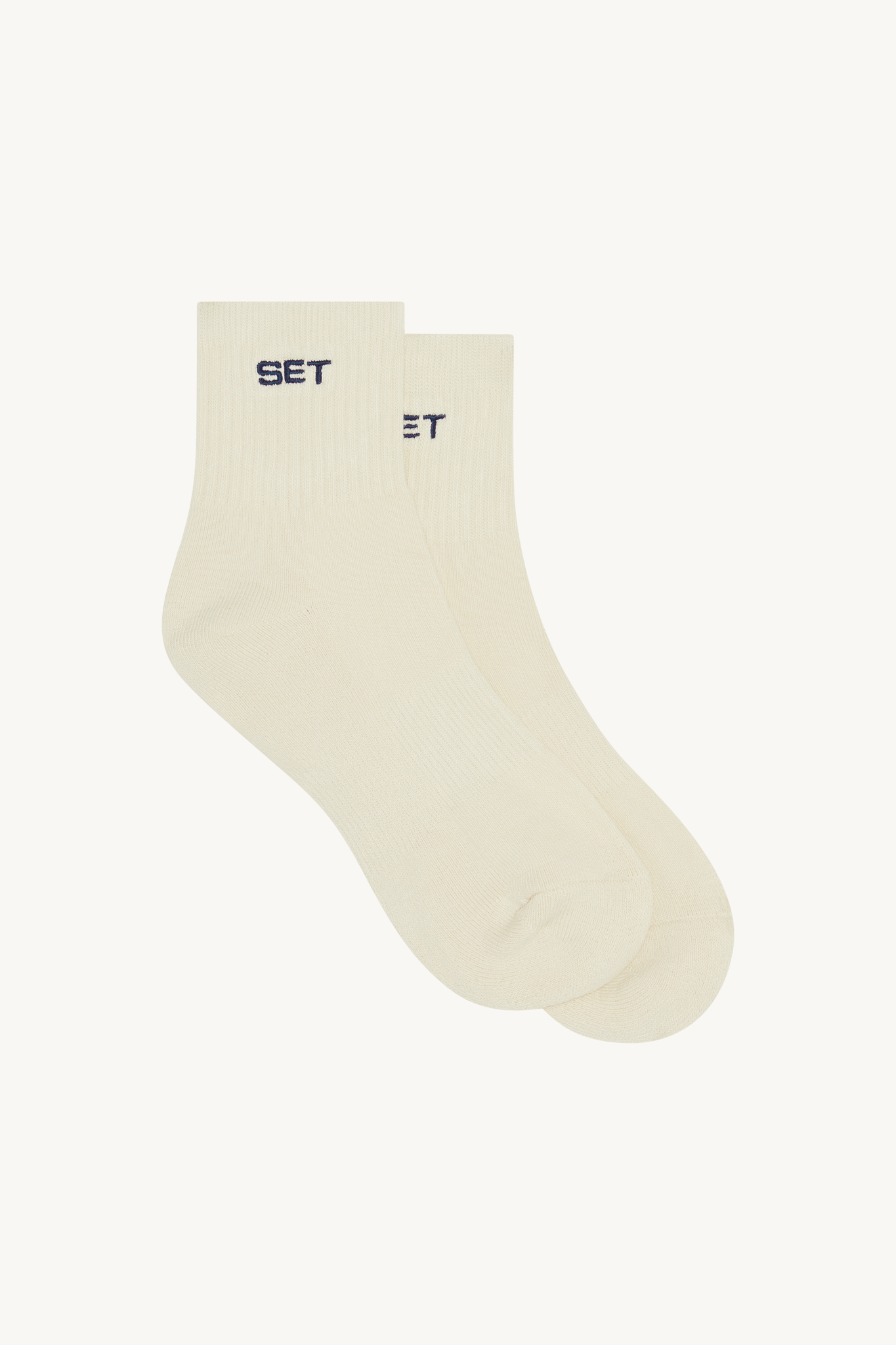 Pair of beige socks with navy text on a white background