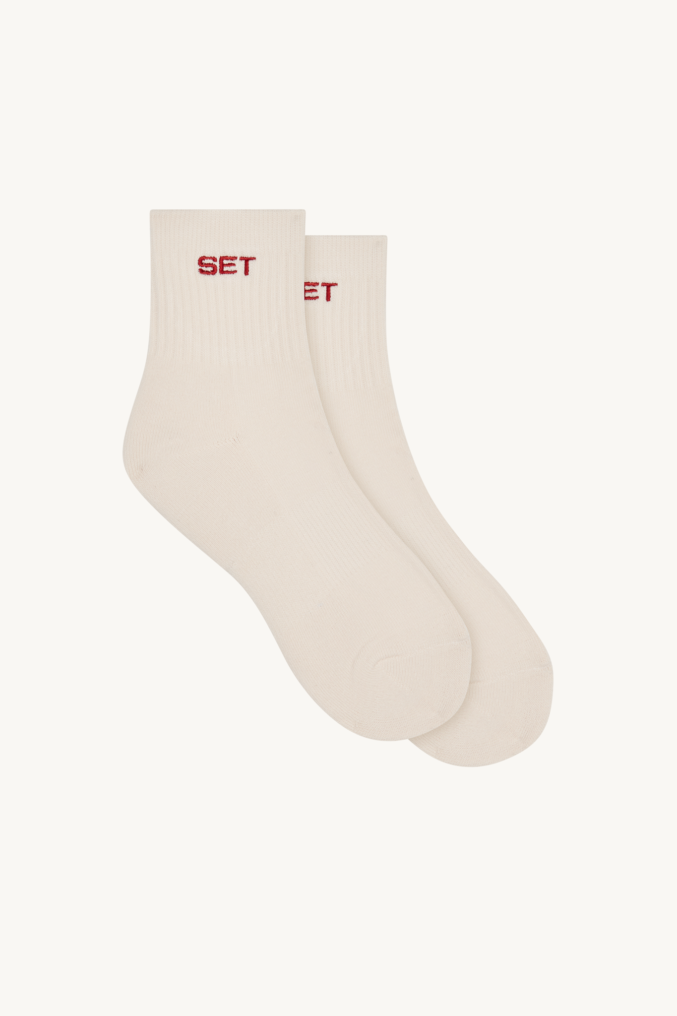 Pair of beige socks with red text on a white background