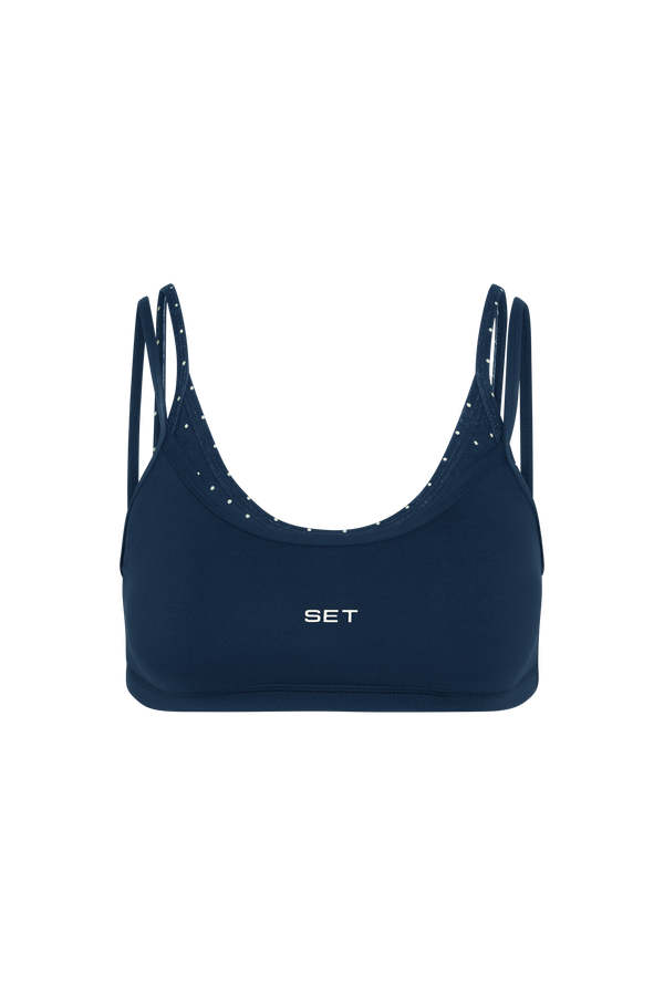 Navy blue sports bra with thin straps on a white background