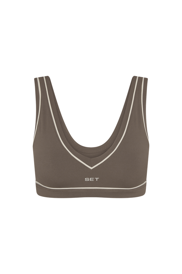 Brown sports bra with white trim on a white background