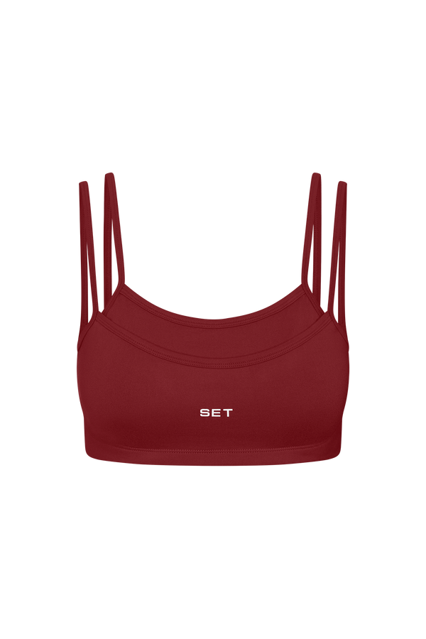 Red sports bra with thin straps on a white background