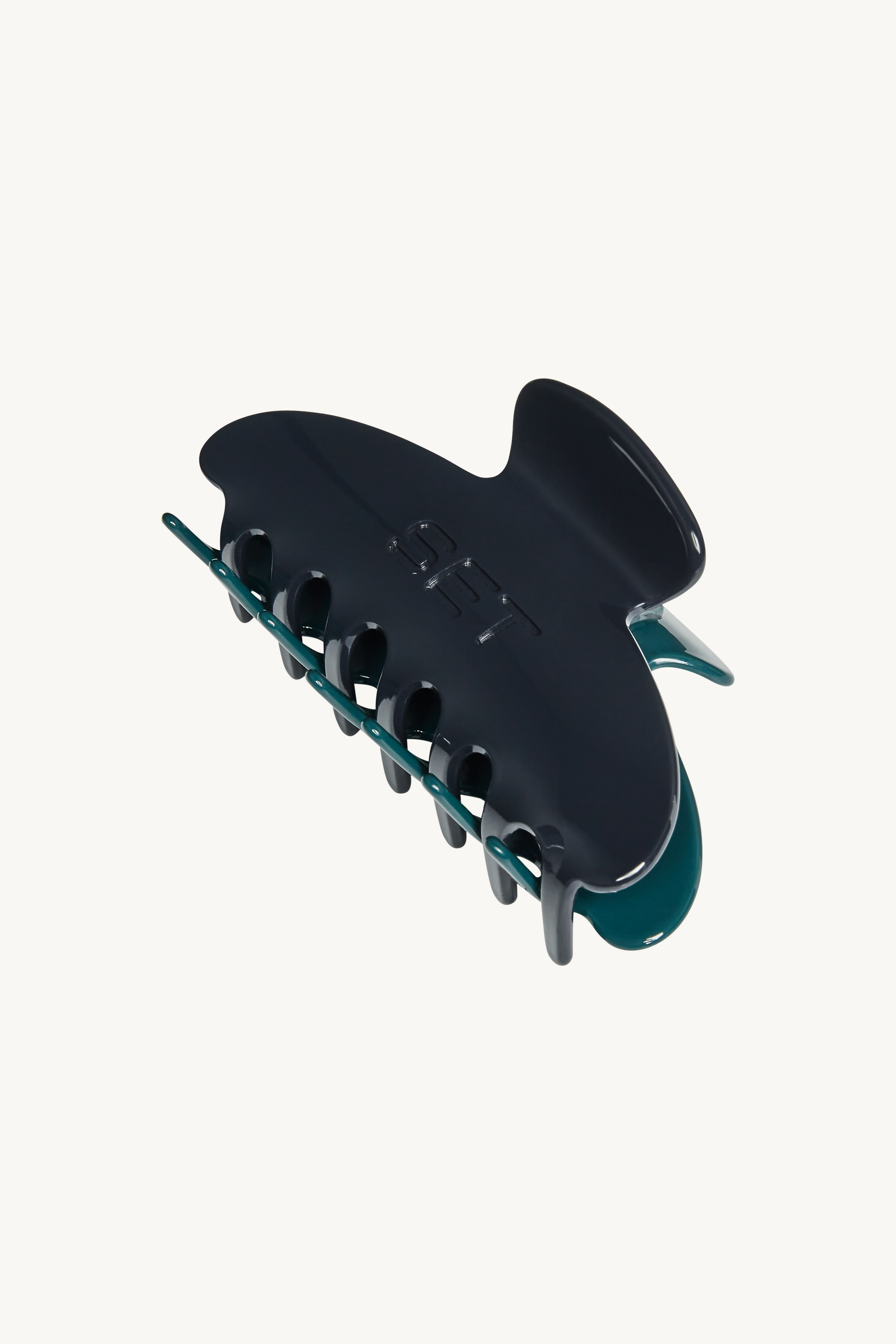 Angled view of SET Color Block claw clip Tether Sync in navy and teal showing interlocking teeth and glossy finish on white background