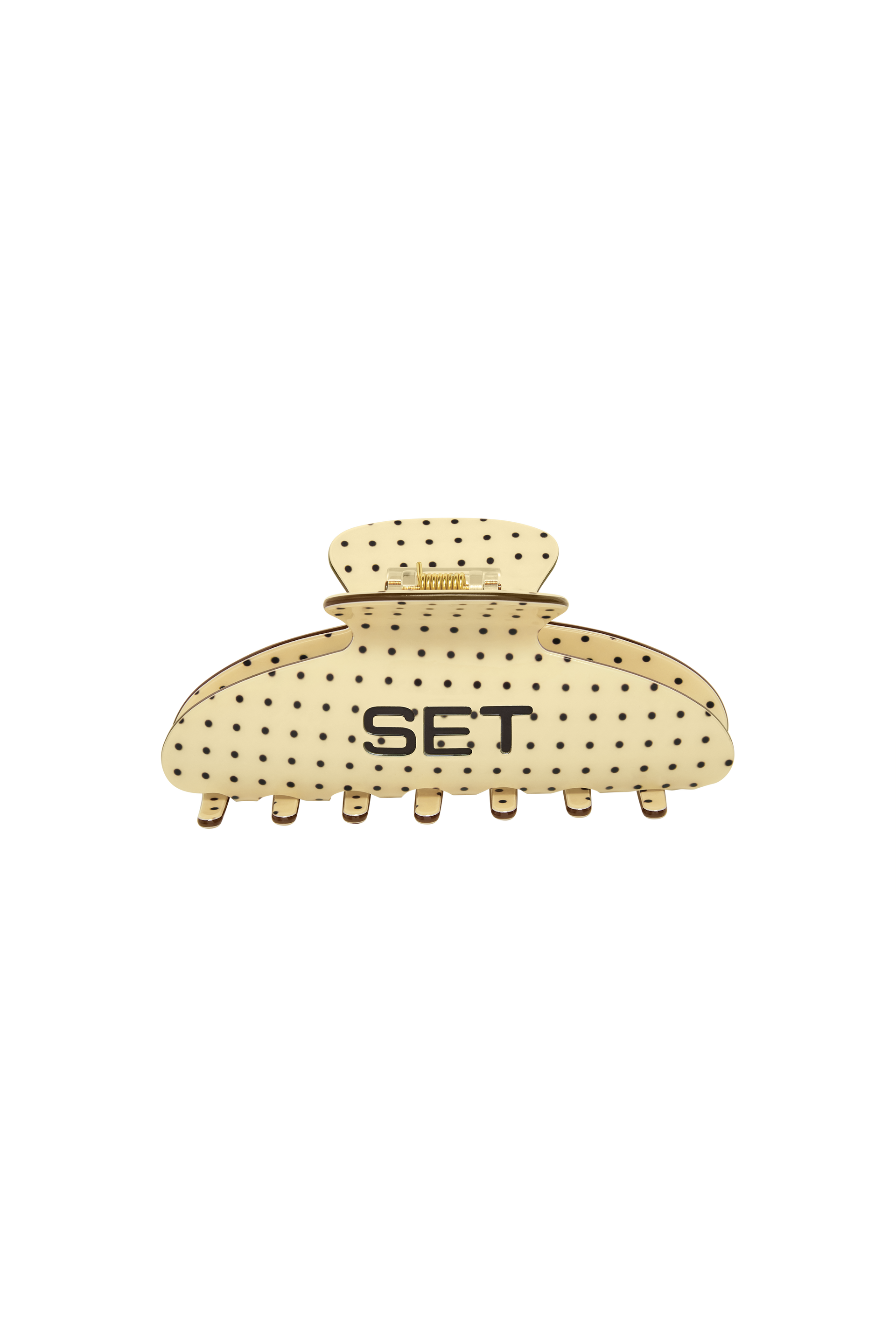 A cream-colored hair claw clip with black polka dots and the letters 'SET' printed on the front, set against a plain white background.
