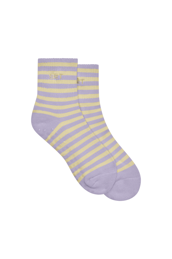 Pair of purple and yellow striped socks on a white background