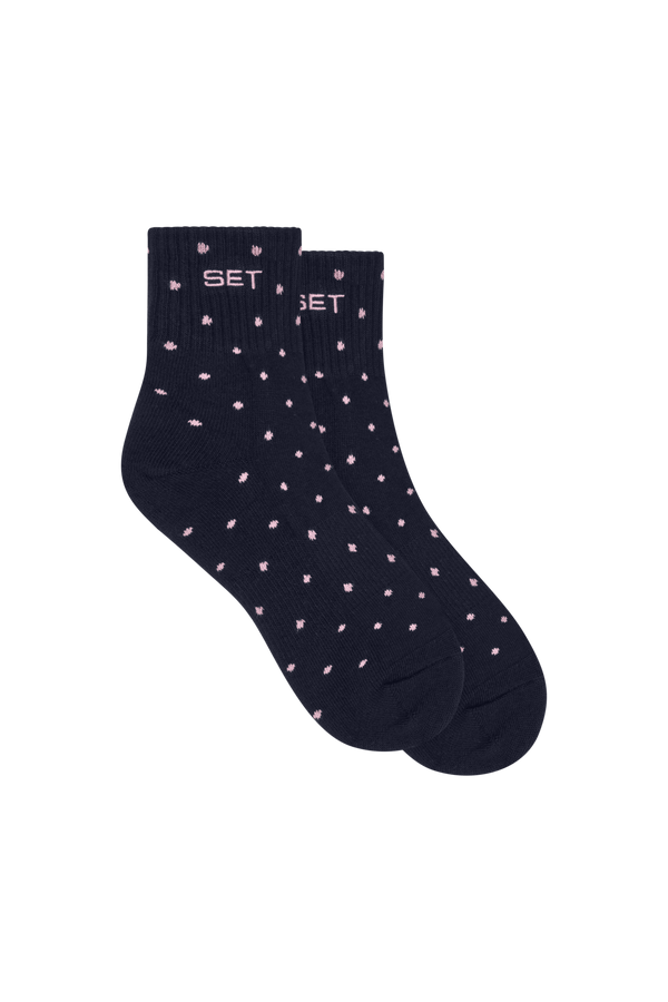Navy sock with pink polka dots on a white background