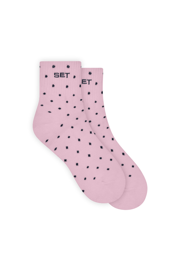 Pink socks with black polka dots on a white background