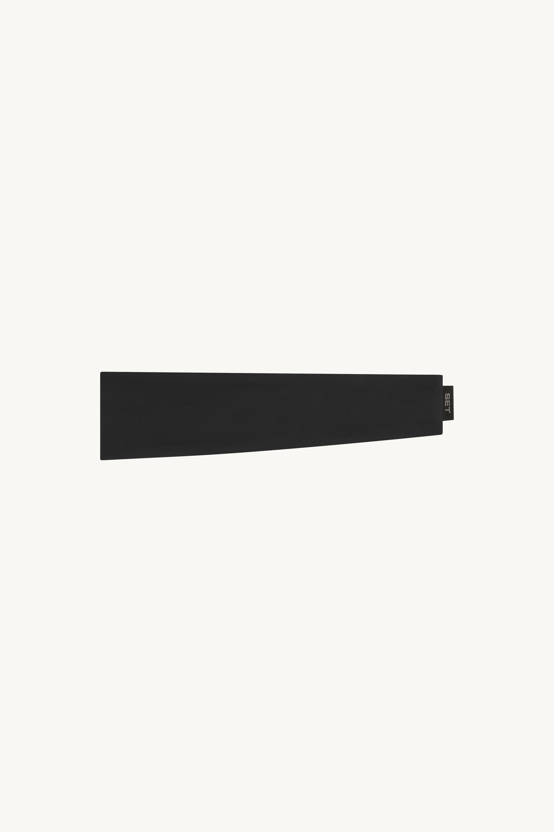 A black athletic headband against a light colored background
