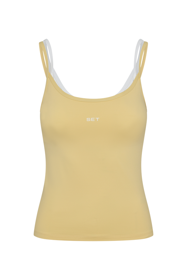 Yellow tank top with white straps on a white background
