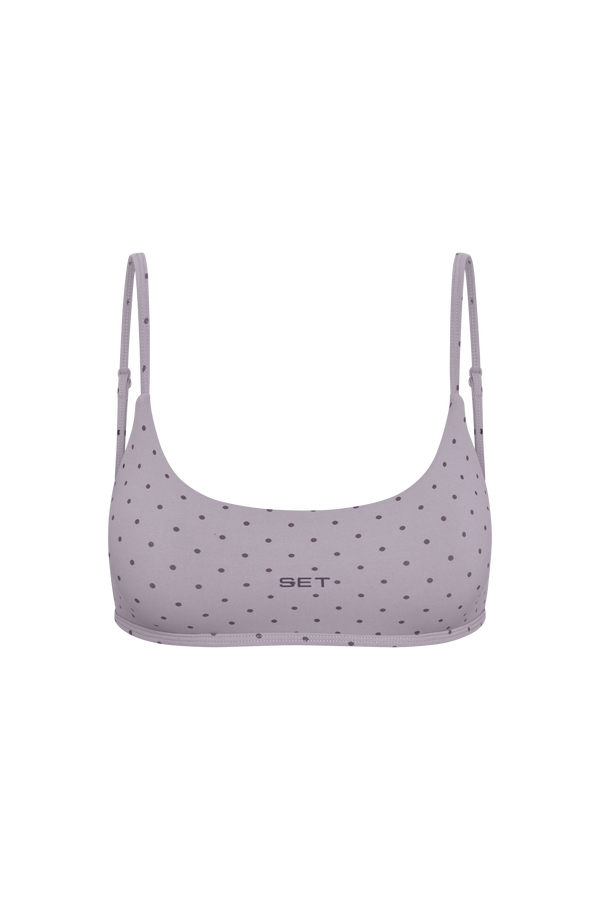 A light purple sports bra with a small black polka dot pattern and the brand name 'SET' printed in black on the center front, shown against a plain white background.