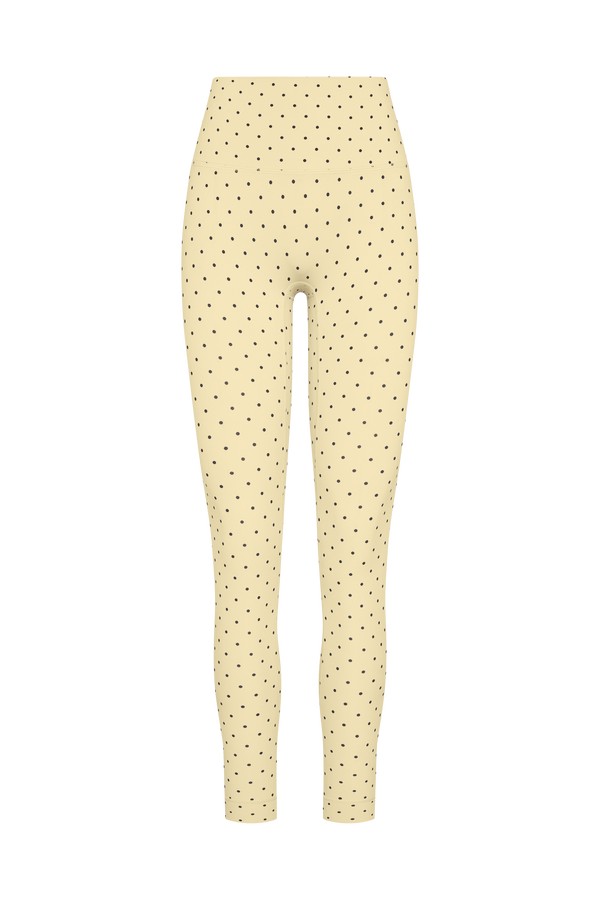 High-waisted leggings in a pale cream color with a small black brown dot pattern, shown against a plain white background.