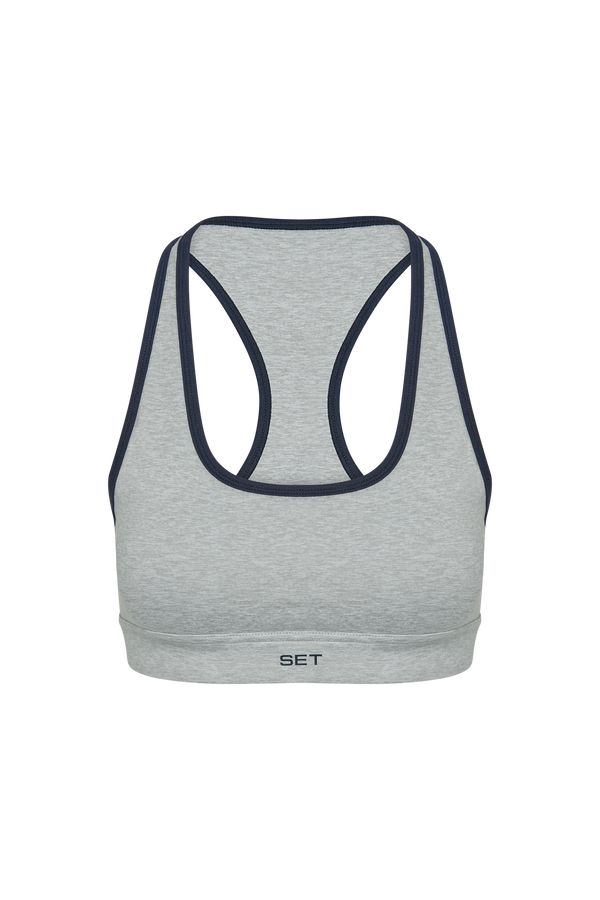 Gray sports bra with navy straps on a white background