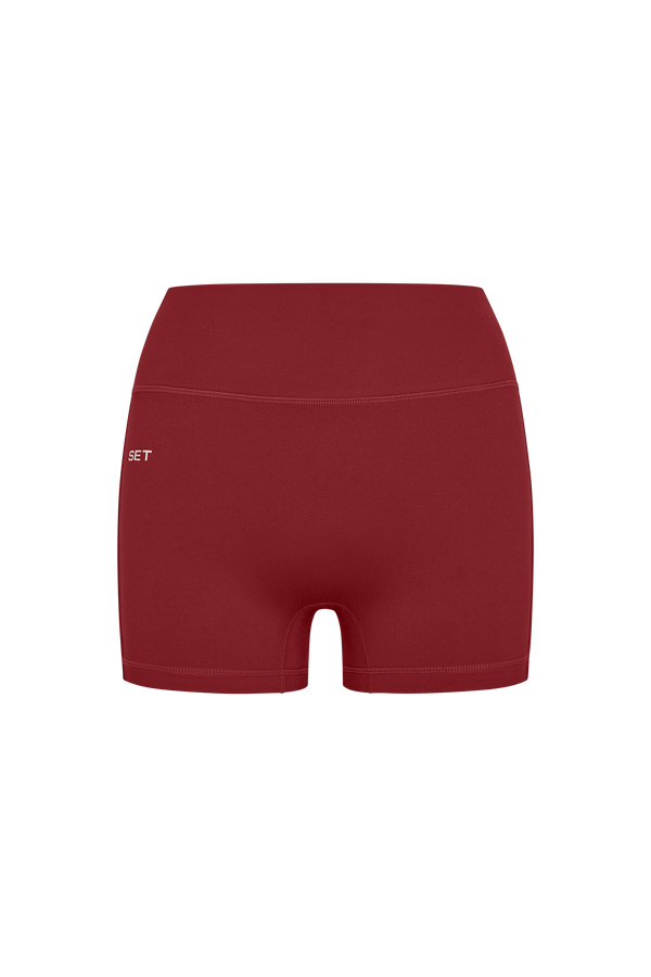Red athletic shorts with a brand logo on a white background