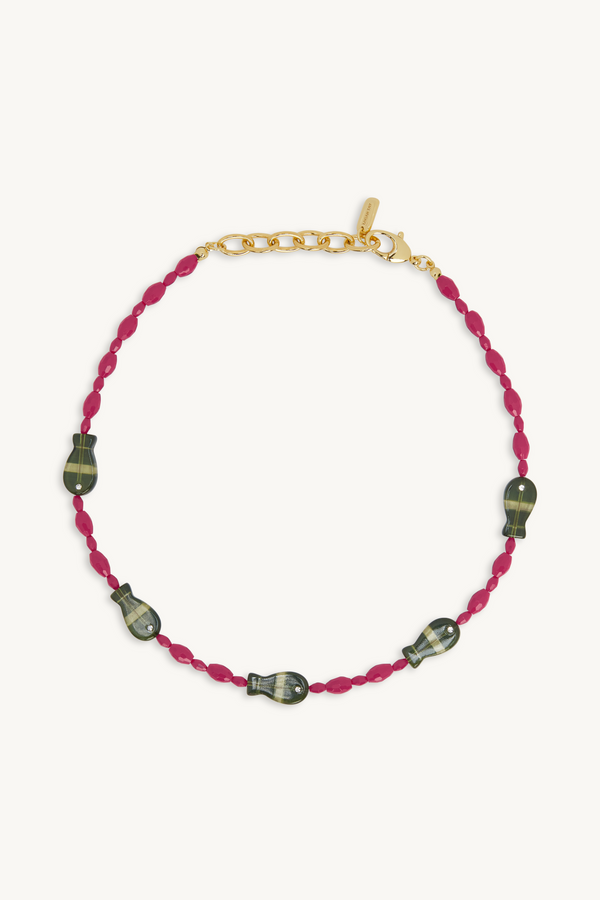 Bracelet with pink cord and black beads on a white background