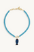 Blue beaded necklace with a fish-shaped pendant on a white background