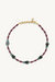 Necklace with red cord and green beads on a white background