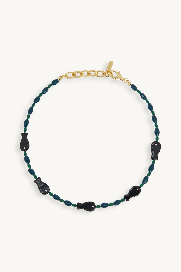 Necklace with green beads and black accents on a white background