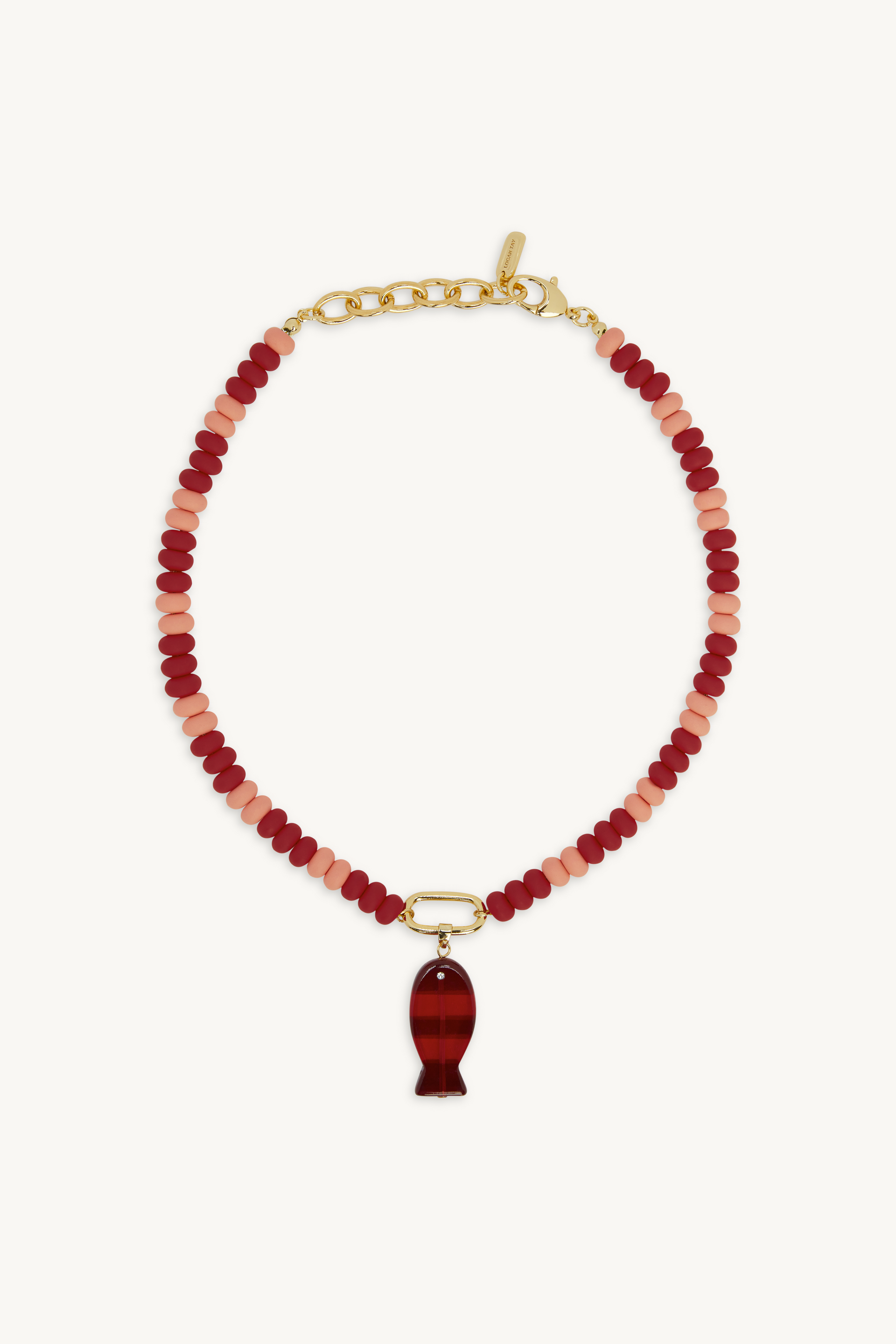 Necklace with red beads and a gold fish pendant on a white background