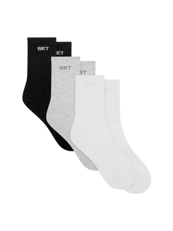Set of three socks in black, gray, and white on a white background
