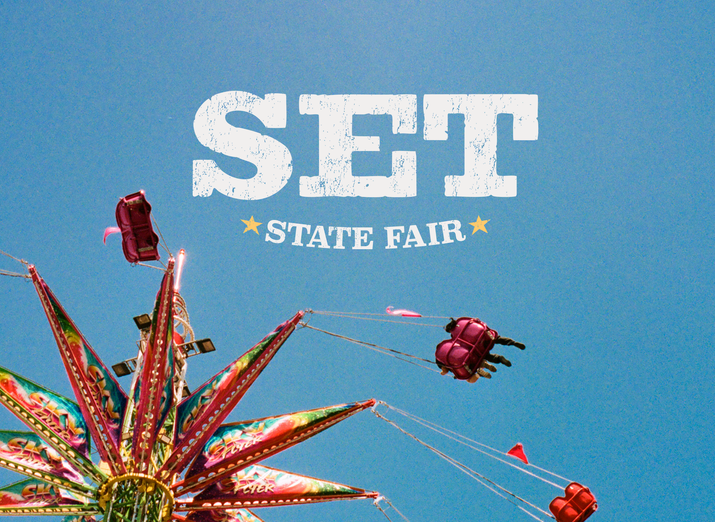 Ferris wheel and carnival ride against a blue sky with 'Set State Fair' text.