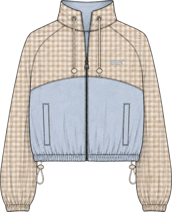 A flat-lay fashion illustration of a cropped zip-up jacket with a beige and white gingham pattern on the sleeves and upper chest, a solid light blue colorblock across the lower torso, and a small light blue 'SET' logo on the left chest.