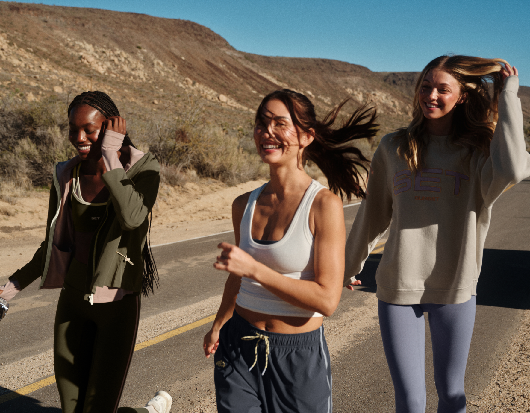 Three girls in activewear walking down a road
