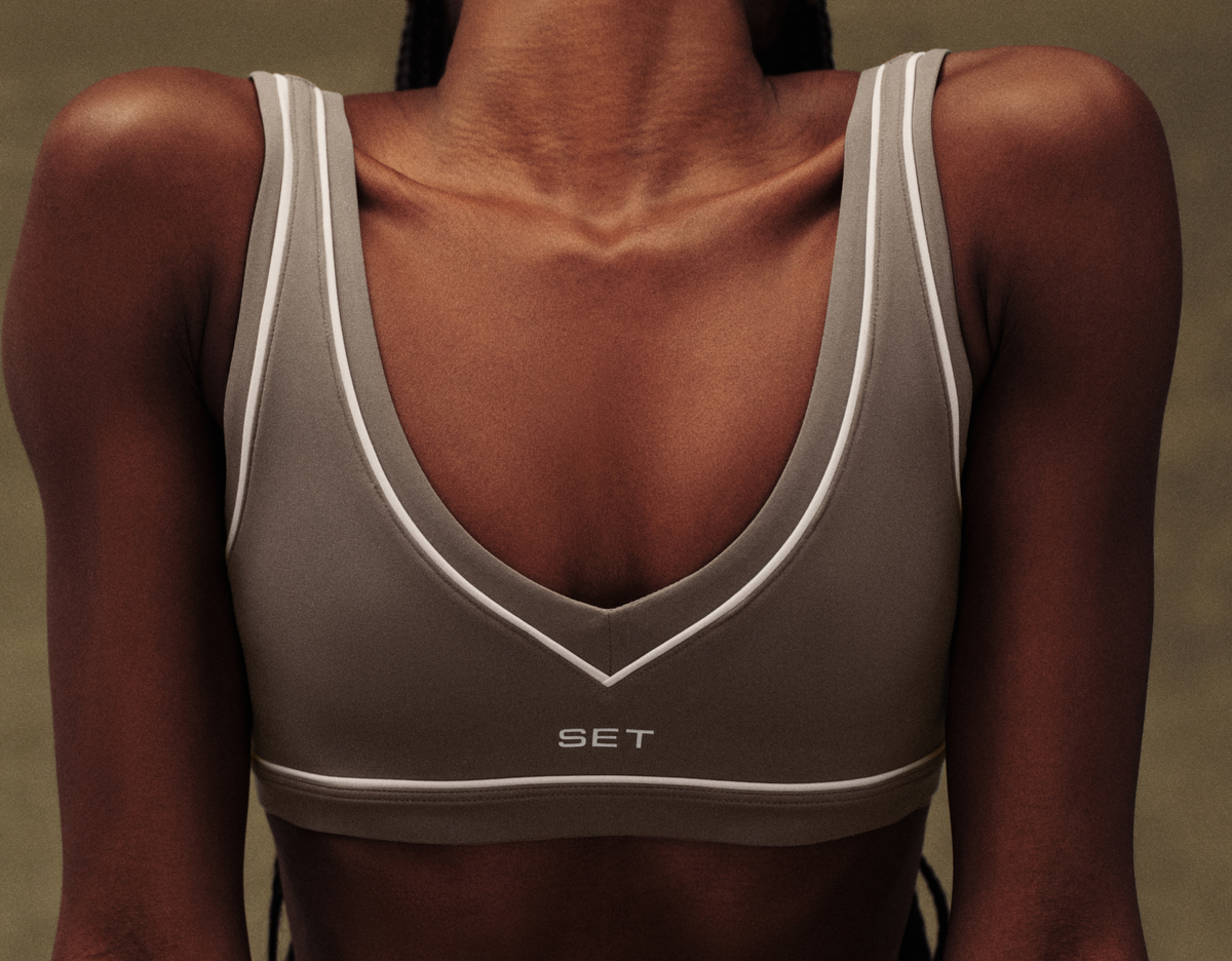 Gray sports bra with white accents on a person against a neutral background