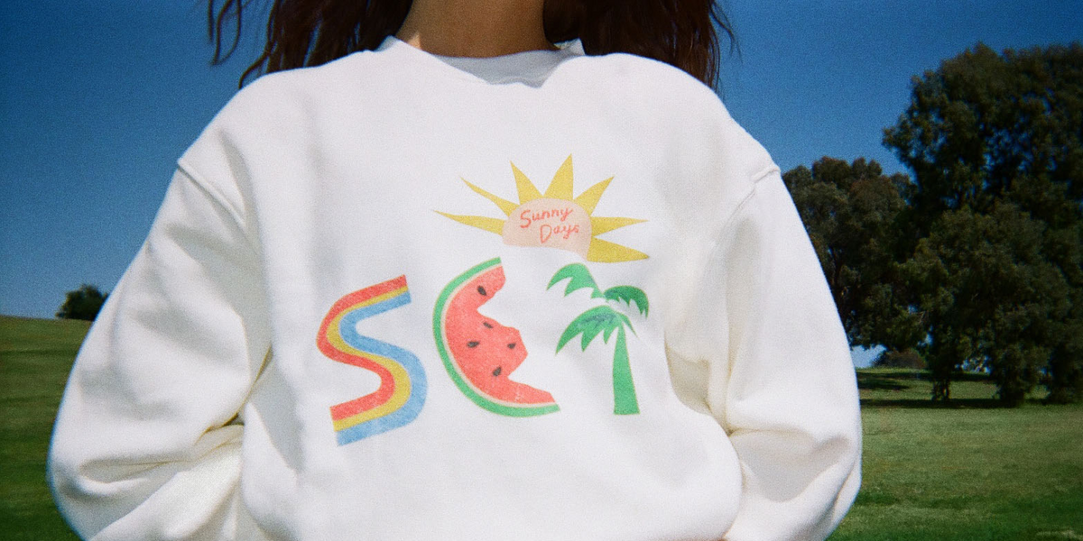Woman wearing a white sweater with colorful graphic