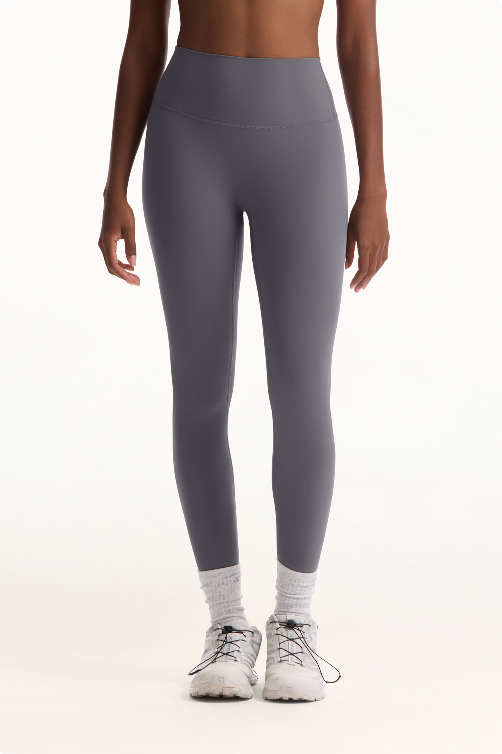 Person wearing gray leggings on a white background 