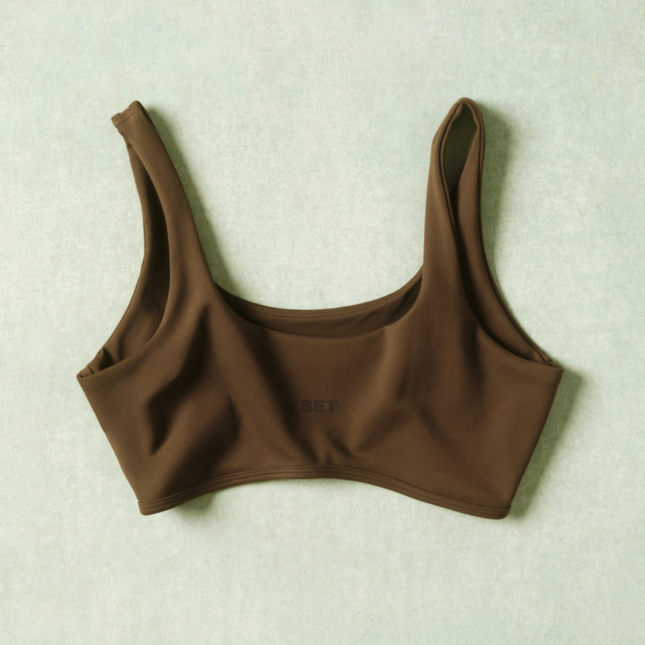 Brown sports bra on a light green background
