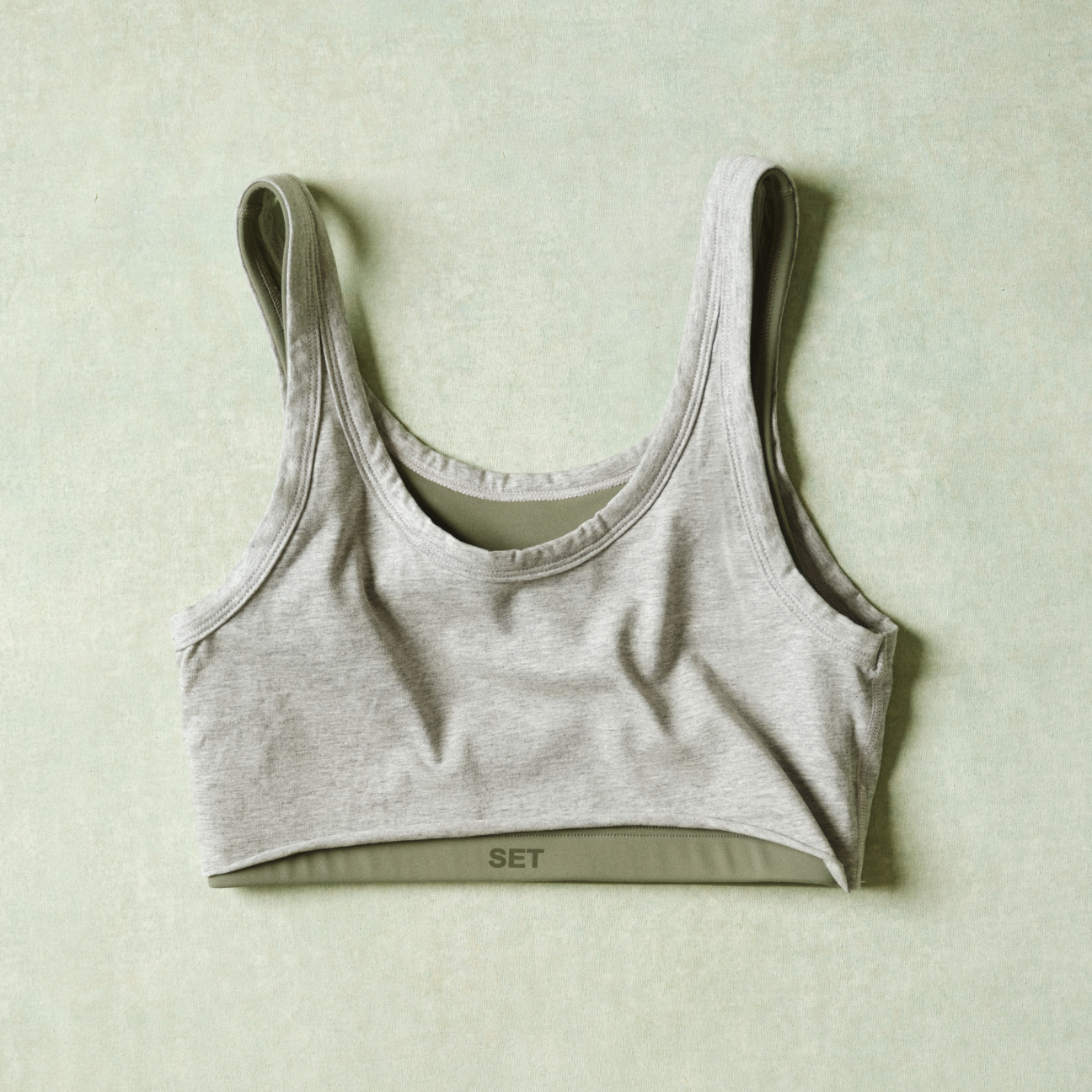 Gray sports bra on a light green background